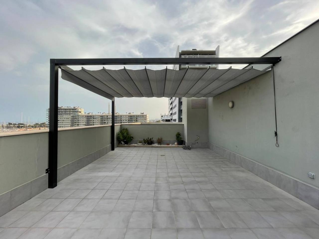 Toldo corredero de ondas sobre terraza de ático