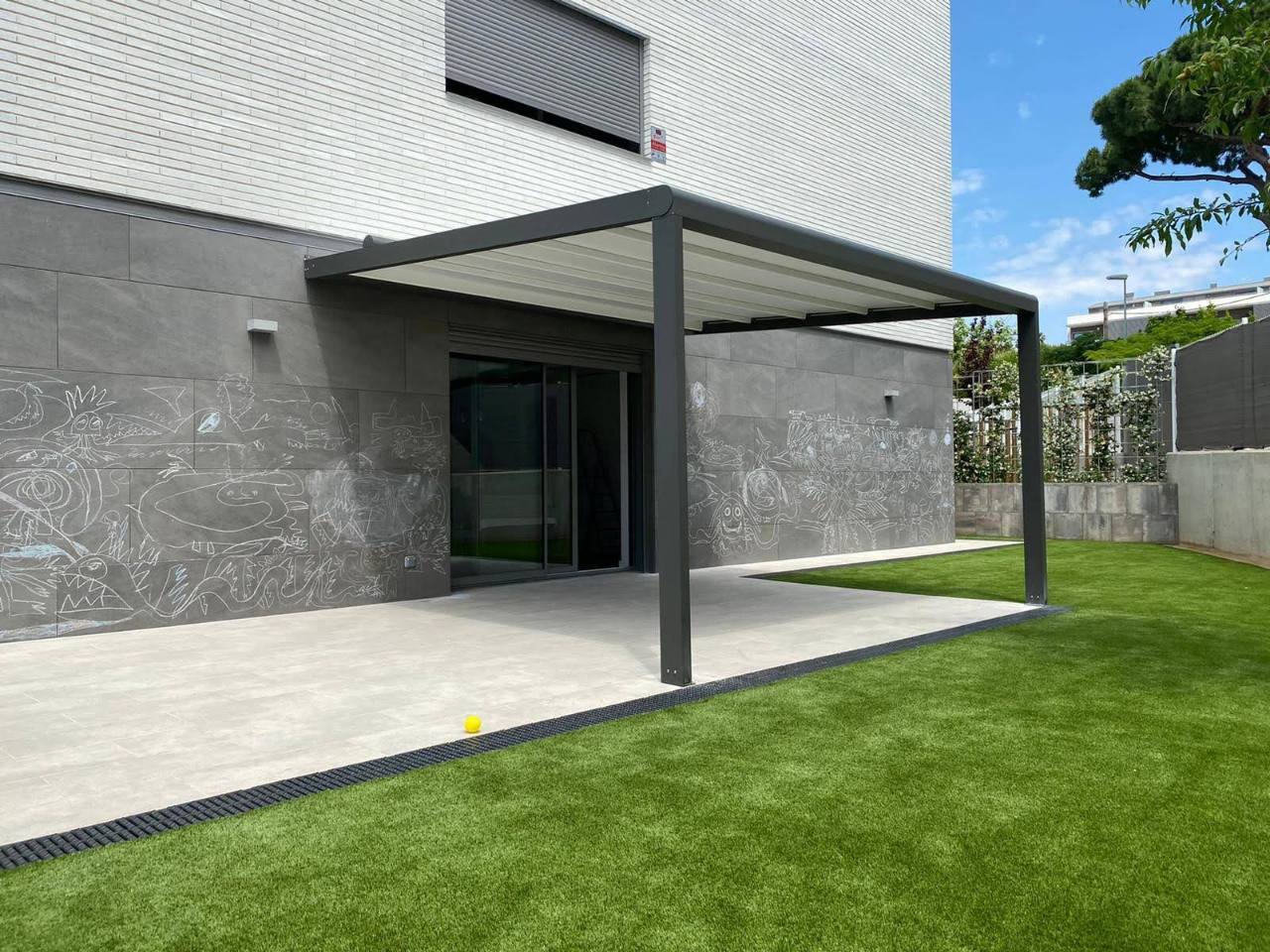 Pérgola textil adosada junto al jardín